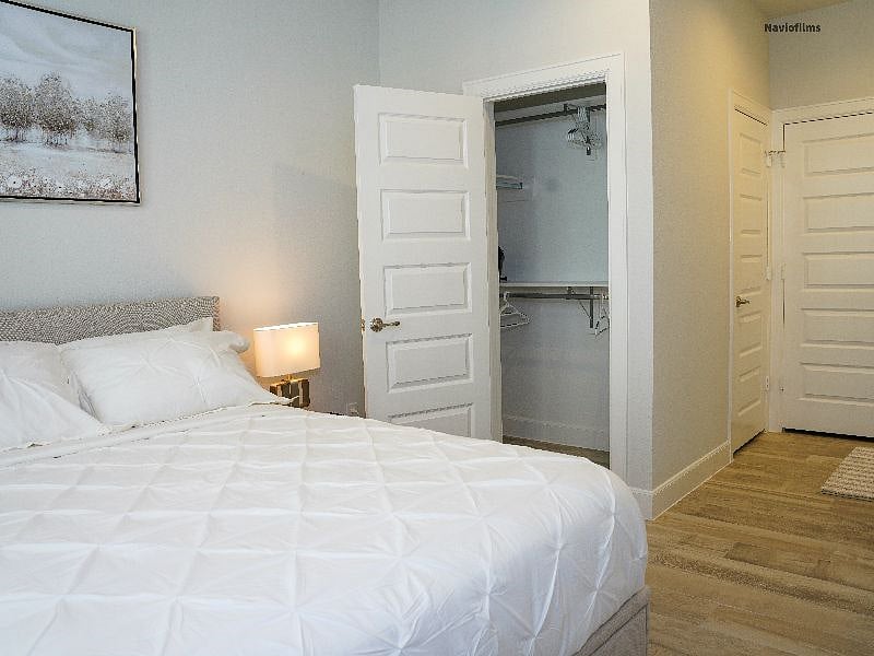 First floor bedroom with view of individual closet. Includes TV, kitchenette and washer and dryer. 