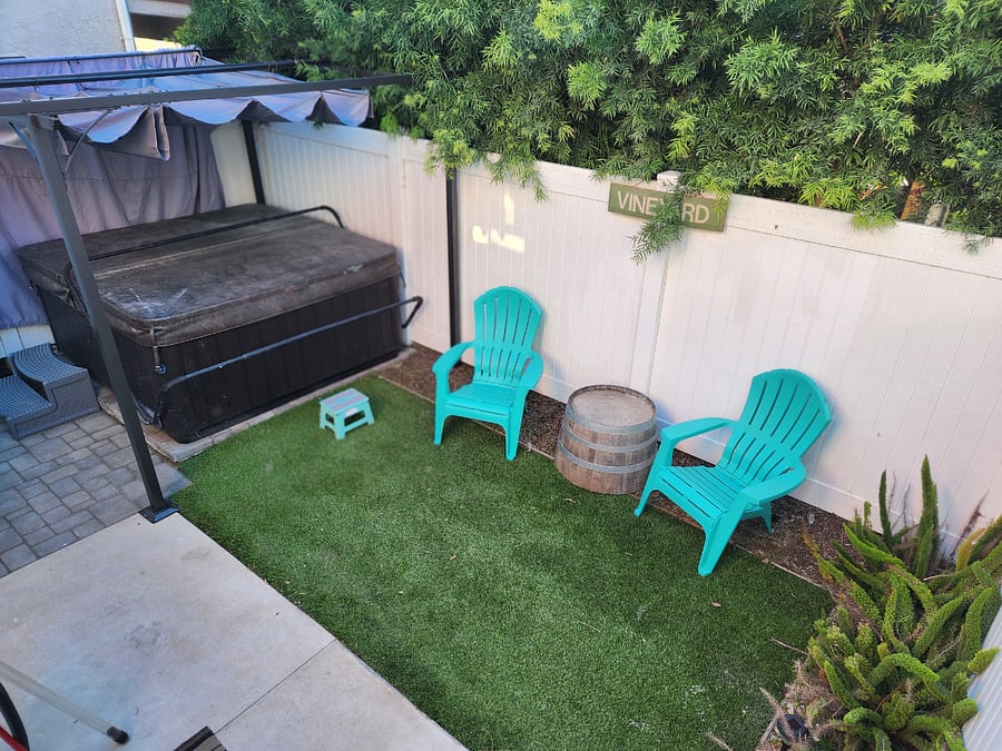 Private hot tub in yard with seating.