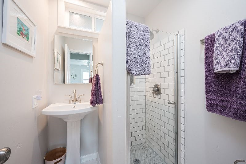 Lower bathroom with tile and a rain shower head.