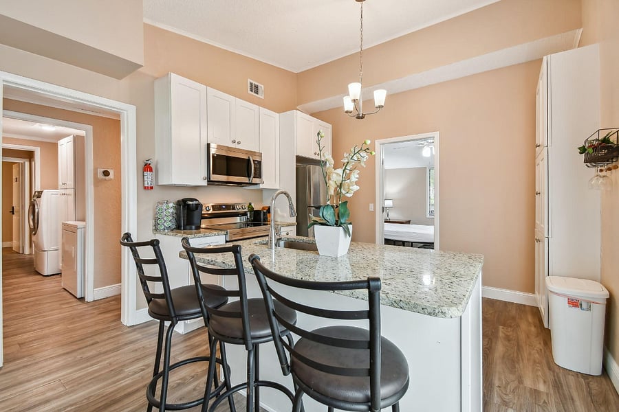 updated kitchen with granite counter tops, custom cabinets stainless steel appliance, and a island to eat at.