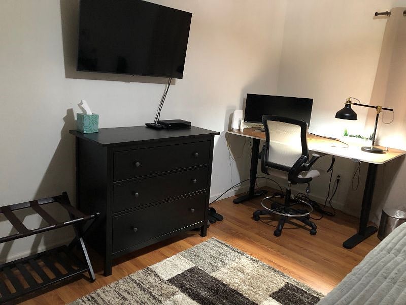 Adjustable work desk with computer screen and high-speed Internet in primary bedroom