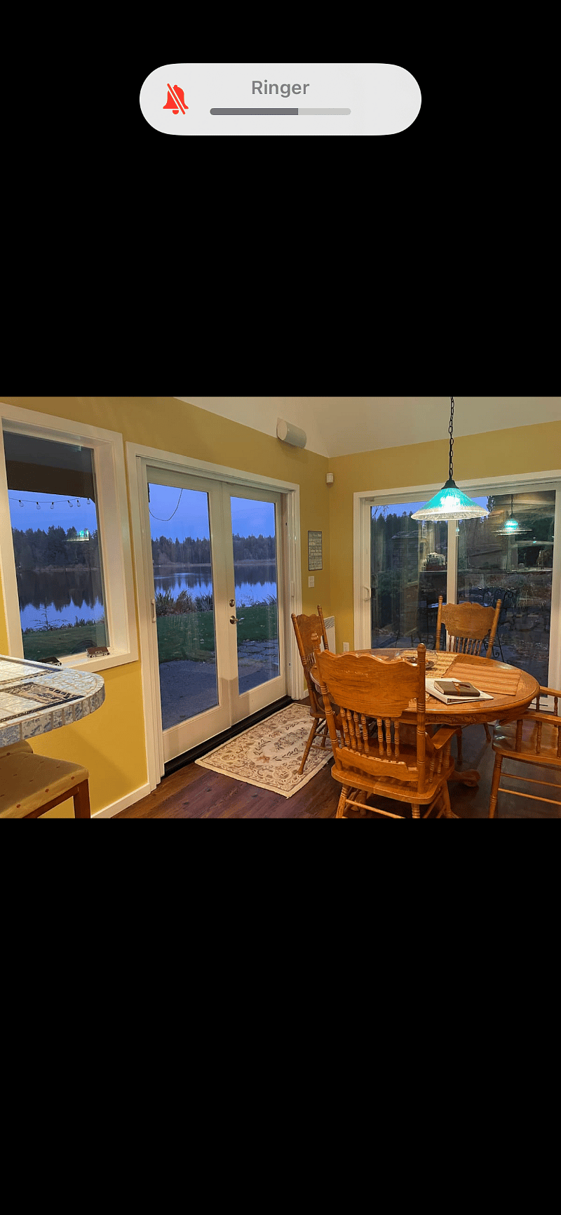 The dining room table looking out on the lake and the private patio with a gas grill. 