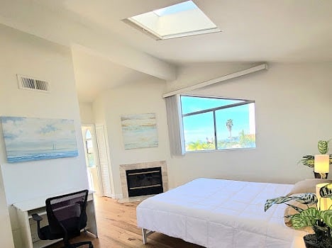 Main bedroom with fire, skylight, computer desk, private patio with ocean views.