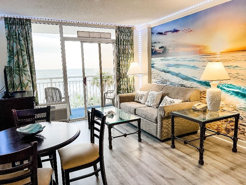 Living room with ocean mural and balcony overlooking the ocean