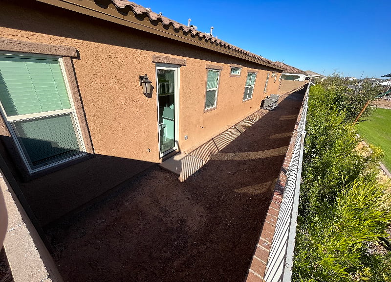 Outside look at attached apartment exterior door, side of house, and green space/park next to home