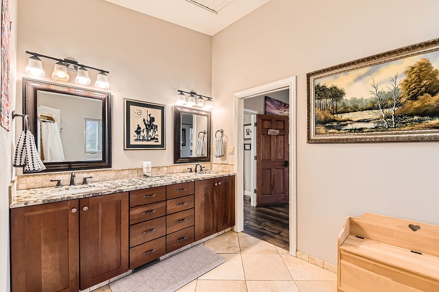The private ensuite bathroom includes two sinks with gorgeous solid stone countertop.