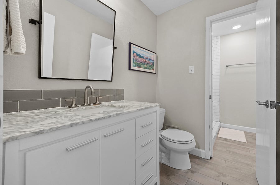 Secondary bath: Jack-and-Jill-style bathroom with a shared shower and separate restrooms.