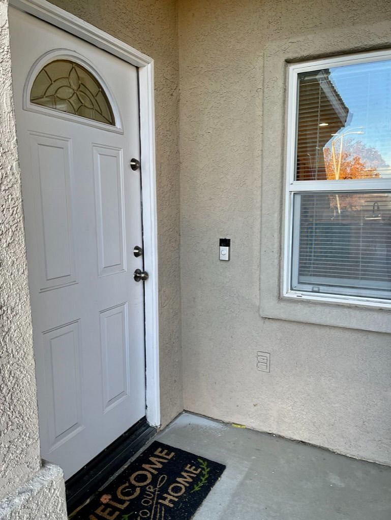 Front door with Ring doorbell and dining room witndow.
