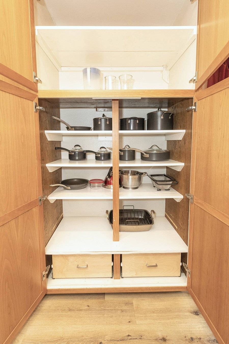 The kitchen is well stocked with cookware, utensils, silverware, and glassware.