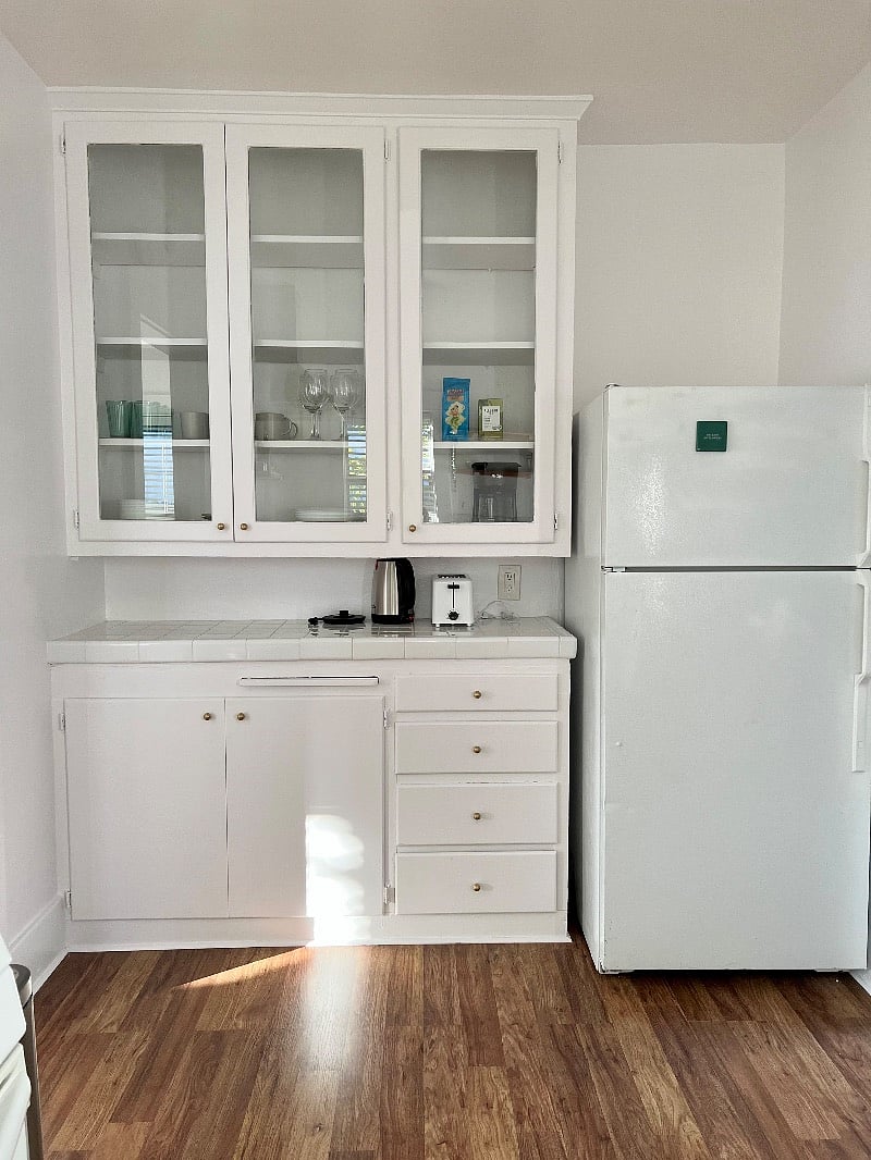 Kitchen with cooking essentials: plates, bowls, cups, mugs, wine glasses, coffee maker, pots/pans, baking sheet, baking pan, mixing bowl, collander 
