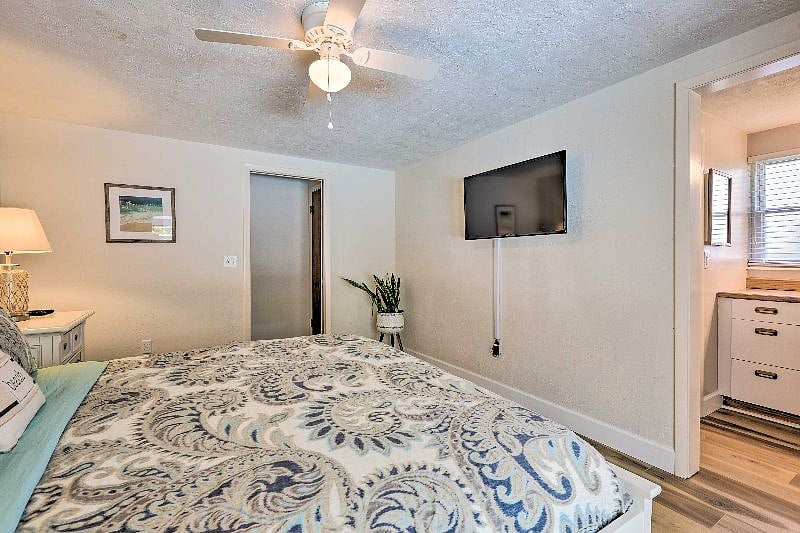 Master bedroom with comfortable king bed and 40" wall-mounted TV with basic cable.