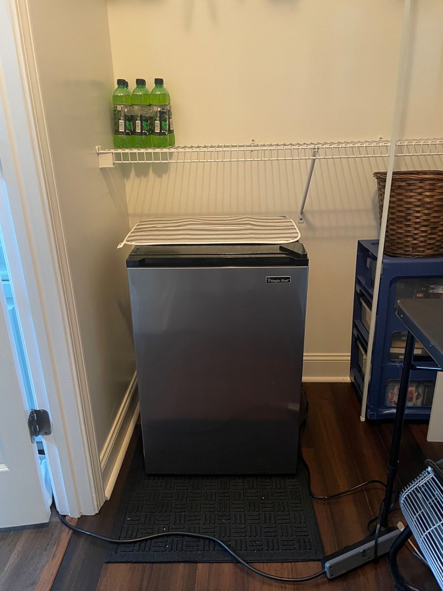 Mini refrigerator for the room with dish mat on top for coffee cup and room dishes
