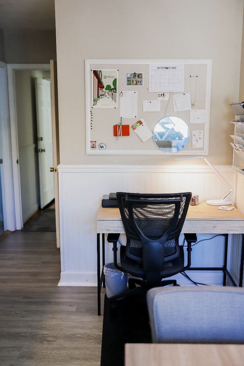Desk with comfortable work chair and bulletin board.
