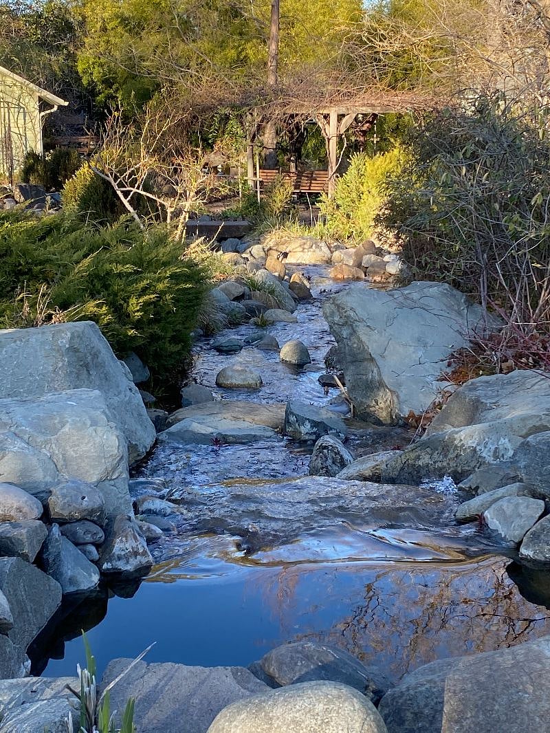 The ninety-foot stream leads to the Koi pond, with places along the way to sit and reflect.