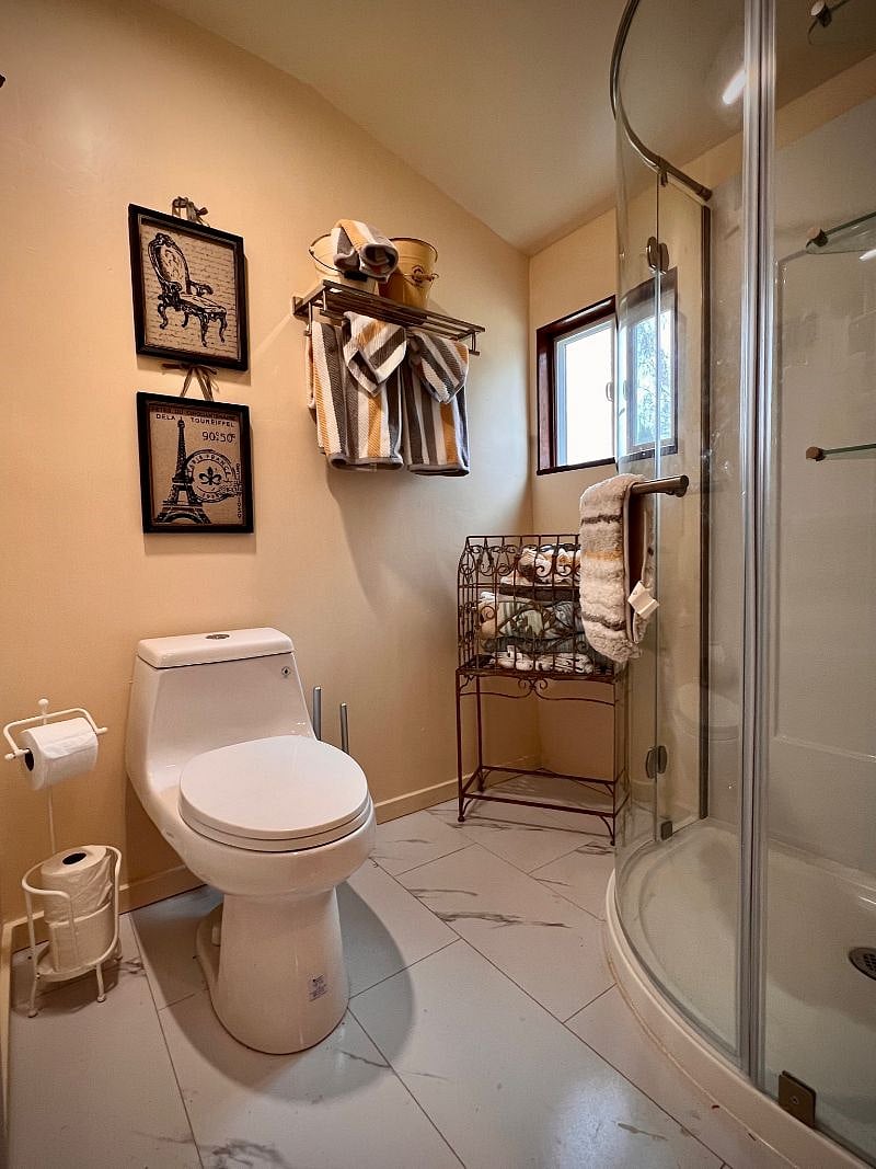 A new bathroom with corner shower and comfy towels.