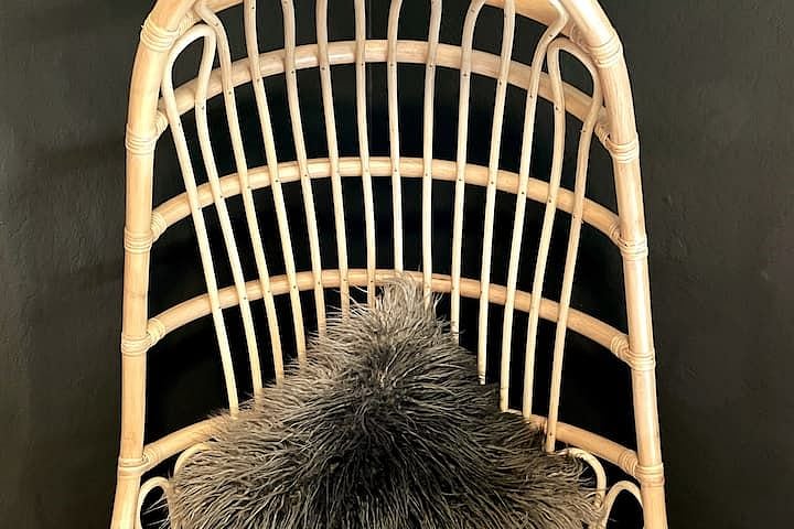 New-bought rattan egg chair, handmade by artisans in Indonesia against a custom-mixed low-VOC wall colour.