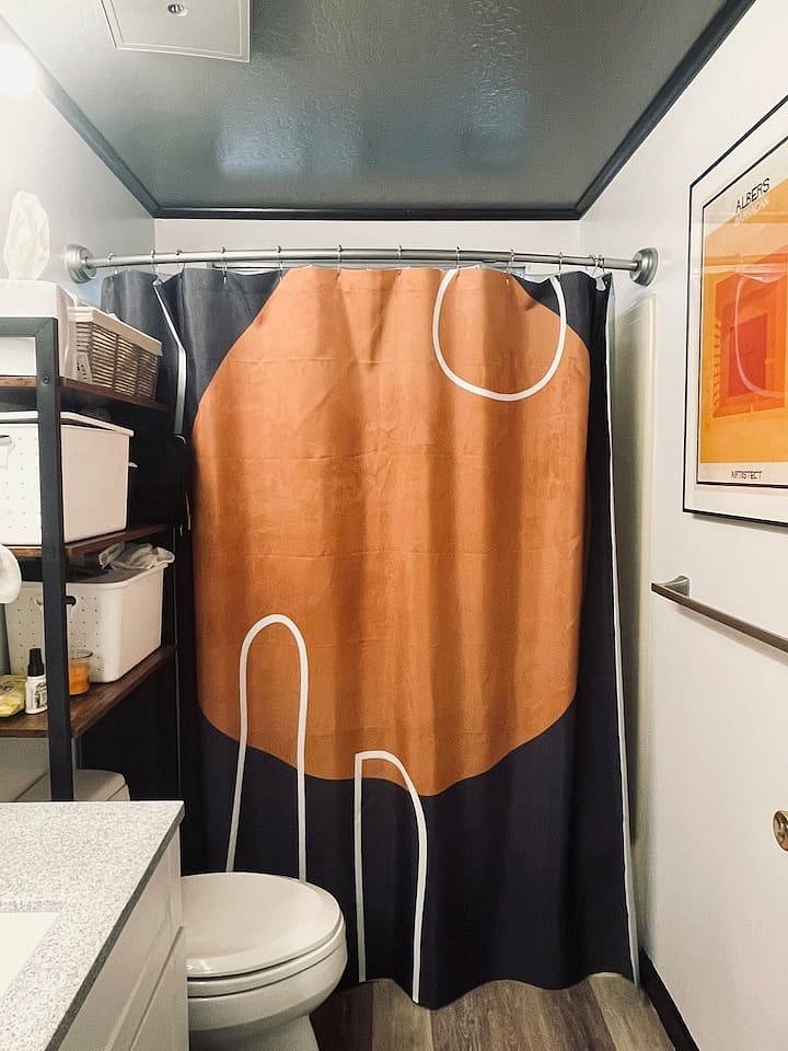 Remodelled bathroom youll share with one other guest room. Theres a tub, handheld shower and storage space.