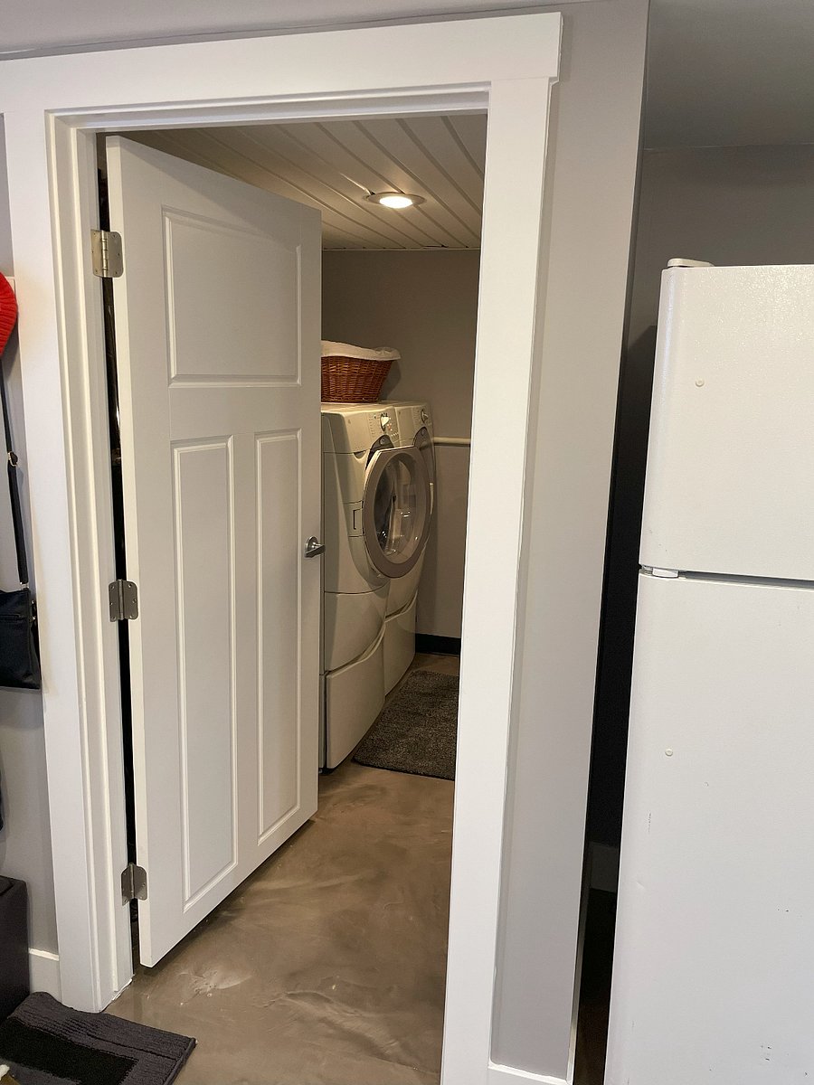 View into laundry room from kitchen. Full size washer and dryer, and space to hang clothes to air dry