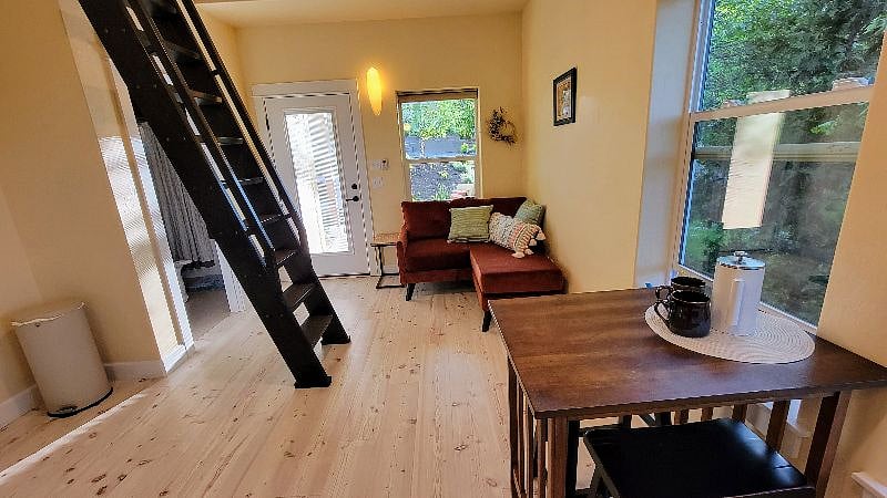 View of the ladder/stairs to the loft and the very cozy loveseat/lounge. Lots of light, airy and sweet space. 