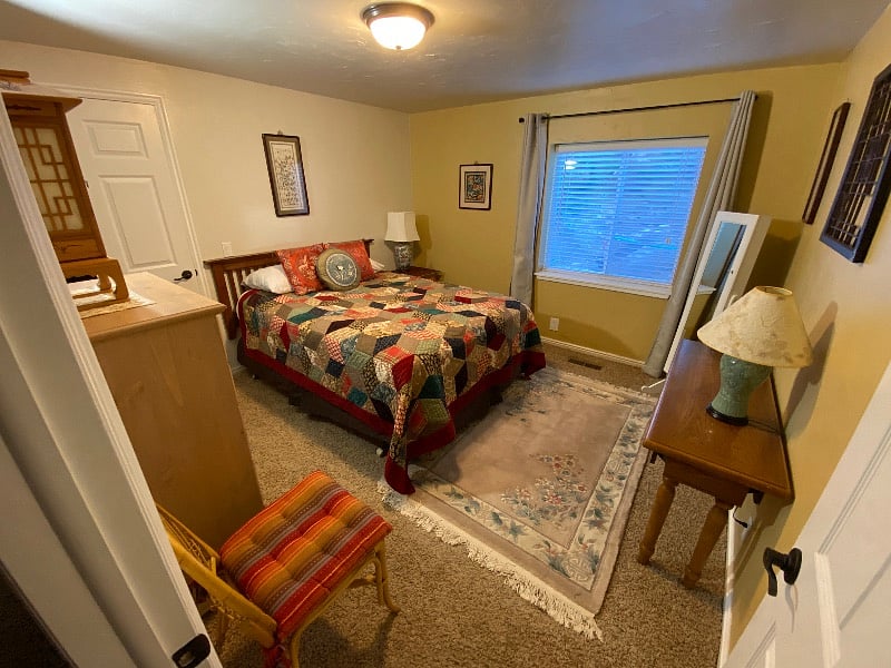 Asia themed bedroom with queen bed and nice linens.