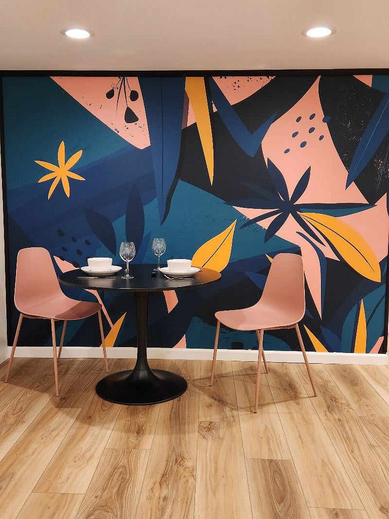 Dining space with tulip table and chairs. Custom wallpaper mural.