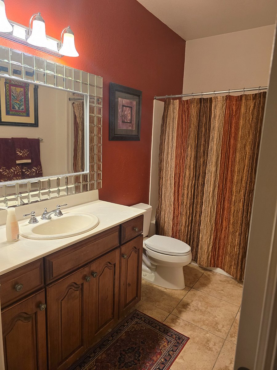 Large private bathroom with full tub, shower and beautiful designer mirror.