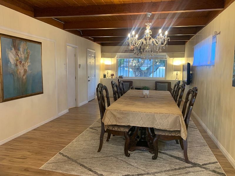 Dining room area, includes a formal dining table (8-10 people), 2 sofa seating, high chair and TV