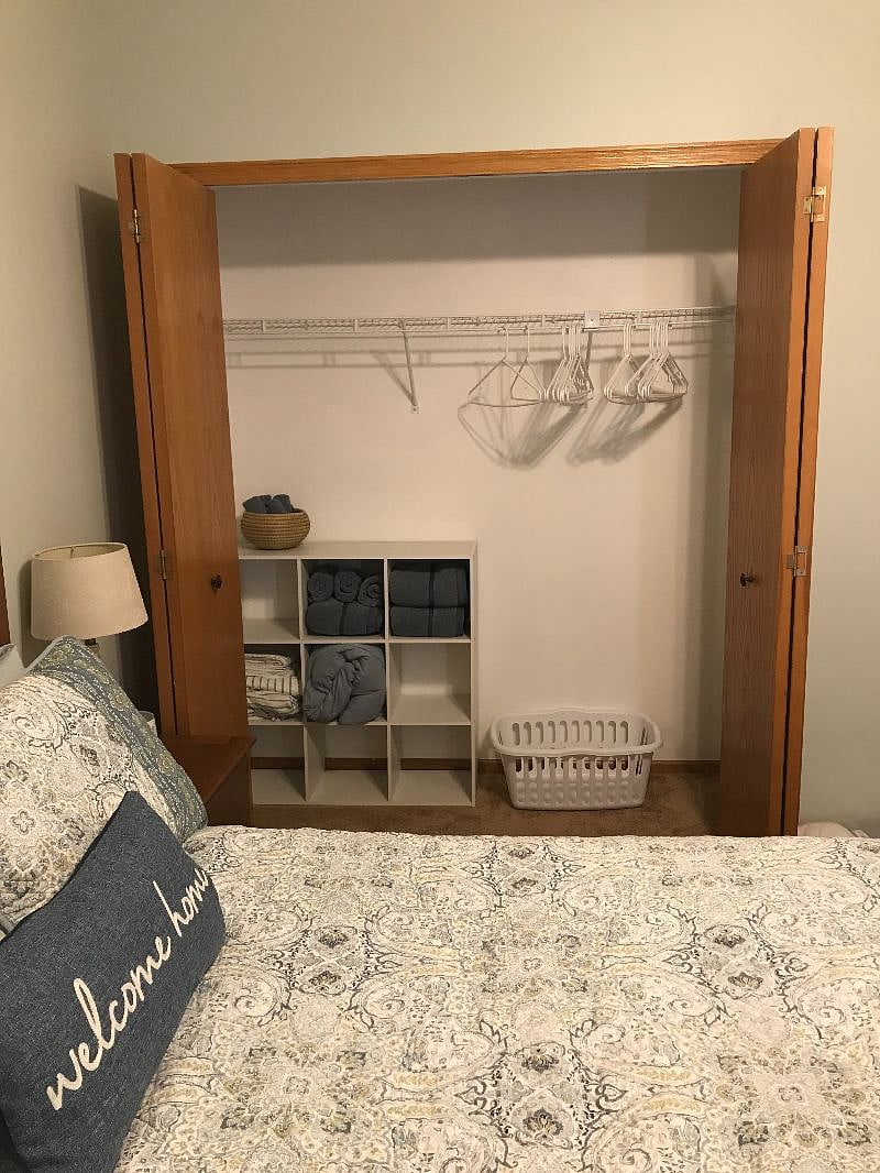 Roomy closet with shelving, hangers, and laundry basket