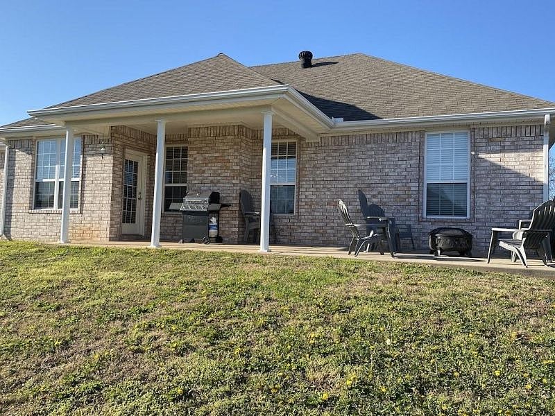 Back covered patio for entertaining with available seating for 8, log burning fire pit and gas grill.