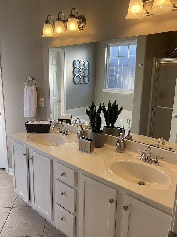 Master bedroom offers two sinks, large mirror and towel racks.
