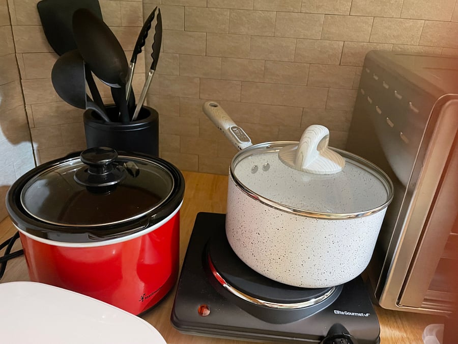 Just showing you some of the cooking tools you have. Theres a mini crockpot, a stove top eye, a countertop grill.