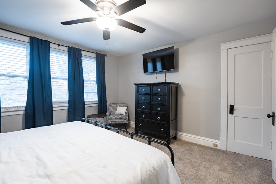 Main bedroom includes dresser and TV.