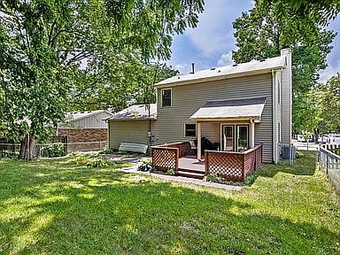 Fenced back yard with porch swing and additional seating.