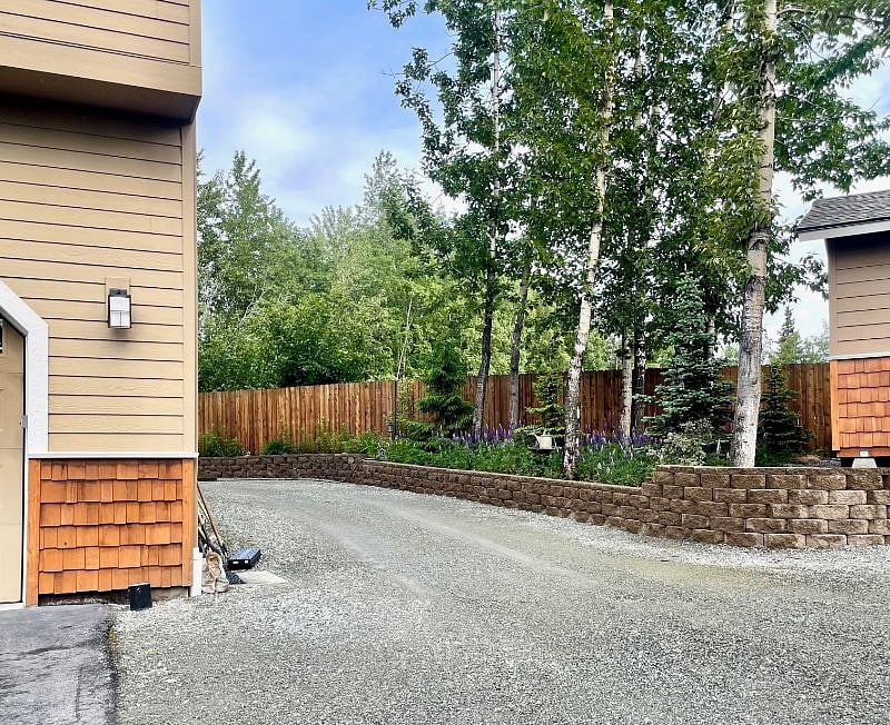 Your own parking accessed at the side of the garage with security lighting and EXTERIOR cameras. Steps to your own exterior entrance on the back of the house.