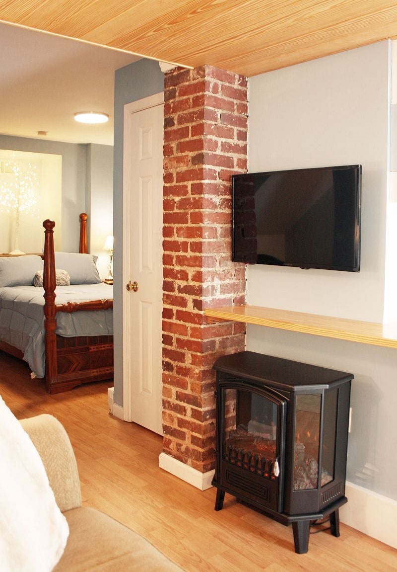 The loveseat looks onto the wall-mounted TV, and the electric fireplace, which provides a 2nd source of heat.