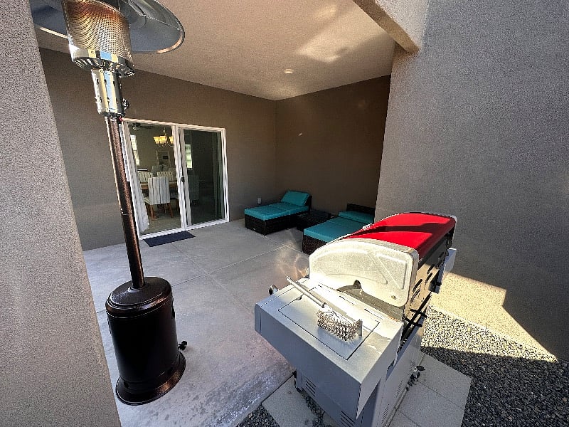 Patio with gas BBQ, seating area, heat lamp and a little fire pit for roasting marshmallows