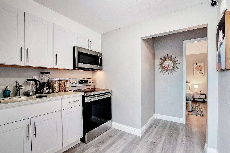 Casita kitchenette: microwave, stove, cups, plates, bowls, eating and cooking utensils