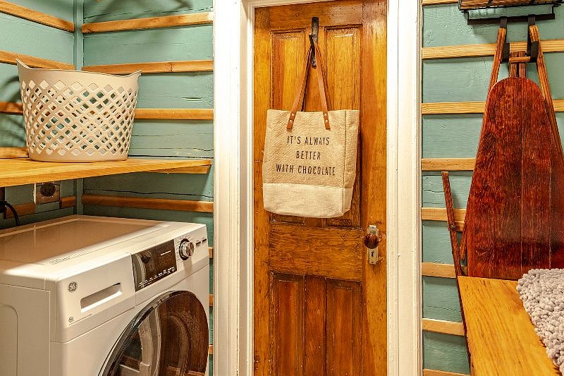 A separate utility space off the bathroom has extra storage space and a work shelf built above the washer/dryer combo. An iron and ironing board are also provided.