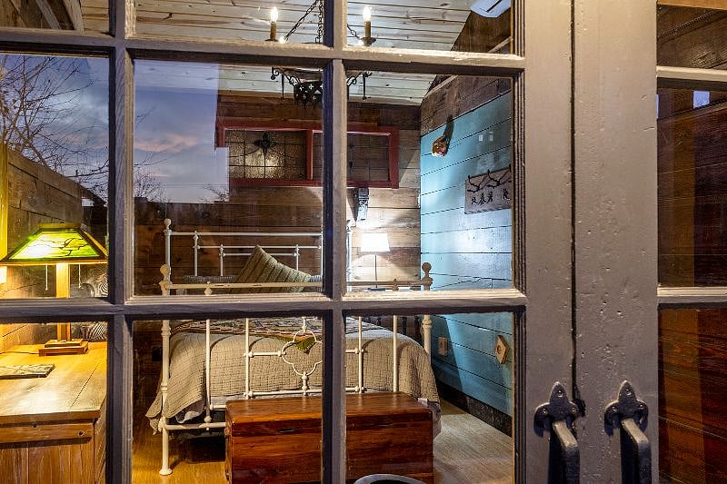Salvaged carriage house doors complete the look for the exterior of this unique and beautiful space.