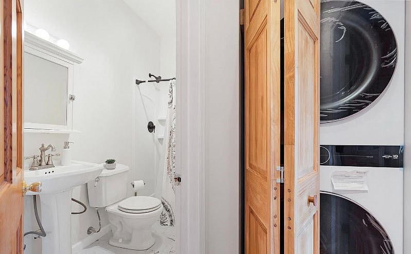 The washer and dryer are located in the top floor in between the second bedroom and bathroom.