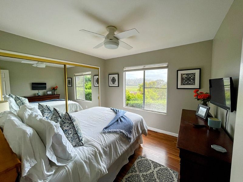 Bedroom with queen bed, dresser and ocean views.