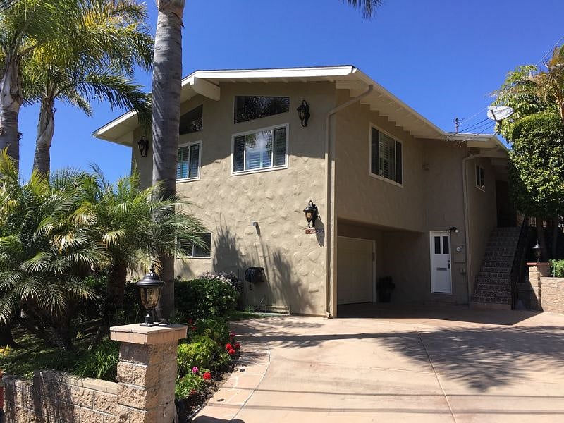 The house has 16 stairs that lead up to the front door. There is parking for up to 2 cars on the right side of the driveway and there is a Tesla charger on the right side of the garage door.