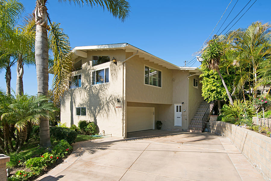 View of the front of the house. The white door is the entrance to this private, downstairs unit. Parking for one car is on the left side of the driveway.