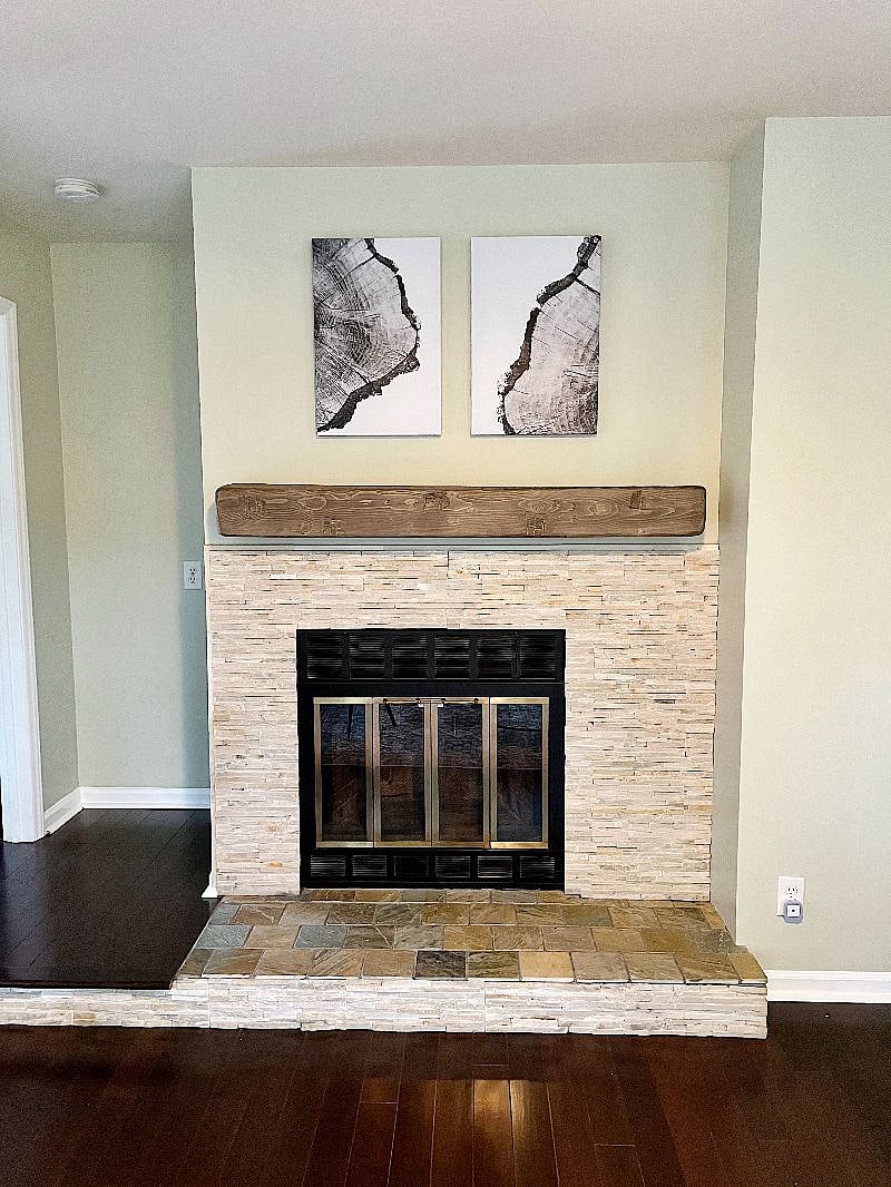 Custom stone work surrounds the fireplace; the mantle is made from a solid beam of pine wood.