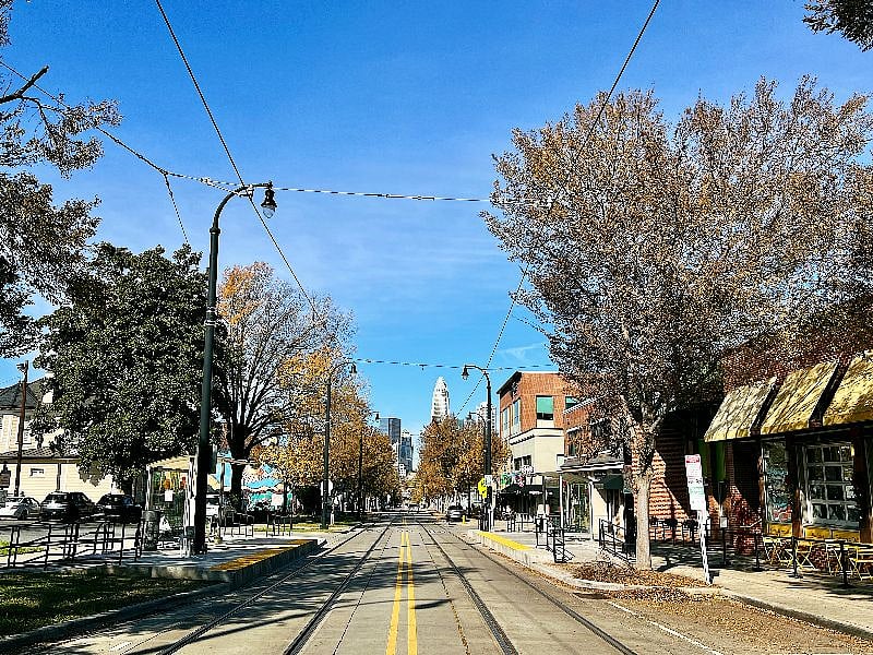 Looking down Elizabeth Avenue towards Uptown: showing the Lynx Gold Line Trolley Station and local shops.