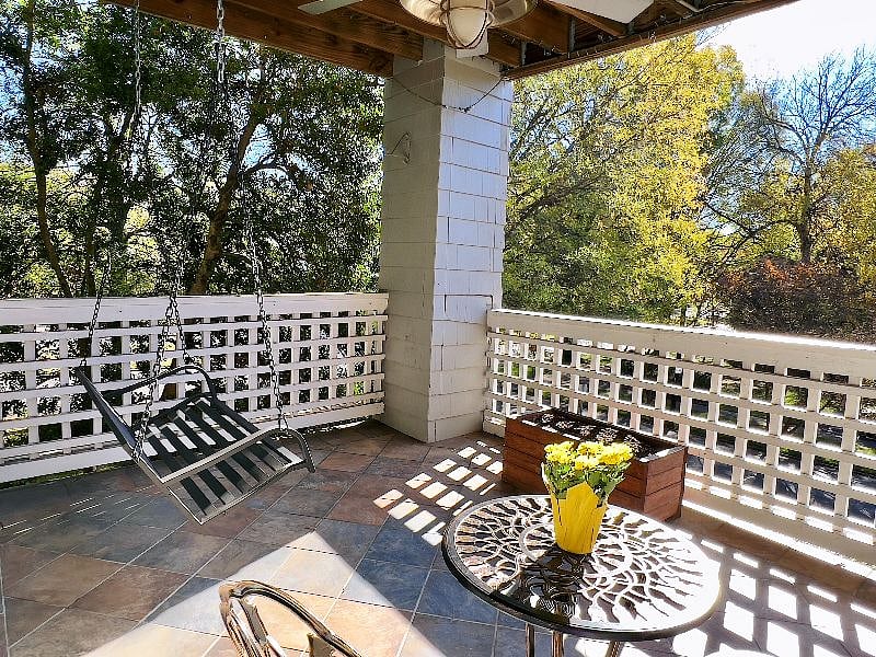 The sun-drenched outdoor balcony overlooks famous Queens Road and its 100-year-old oak trees.