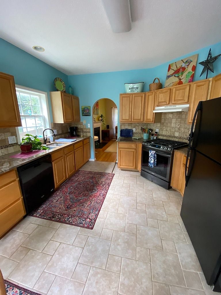 The kitchen has everything you need: pots and pans, dishes, gas range, toaster oven, tile  back splash, dishwasher, tile floor,& back splash ect.