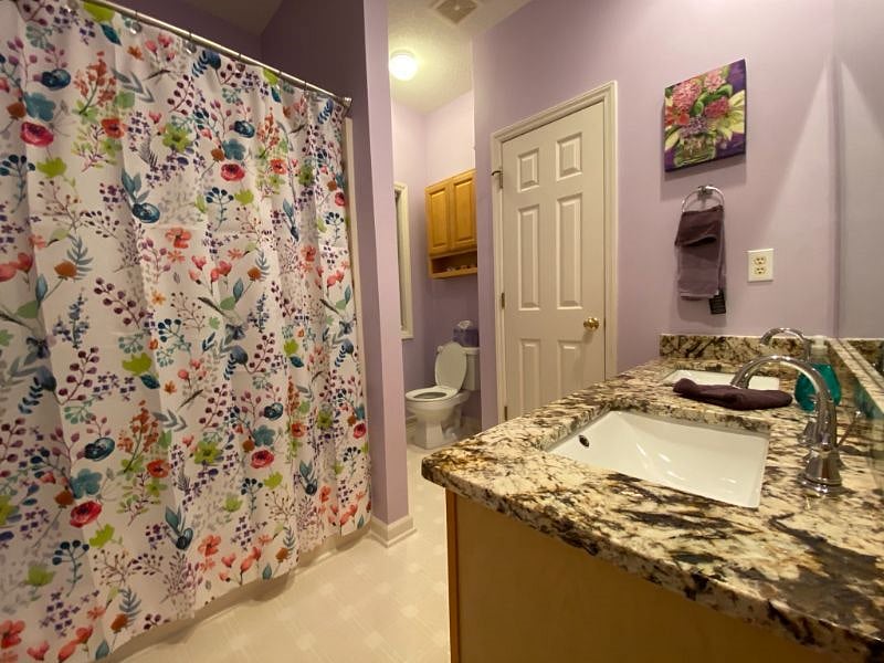 MASTER BATHROOM WITH DUAL SINKS AND GRANITE COUNTERTOPS.
