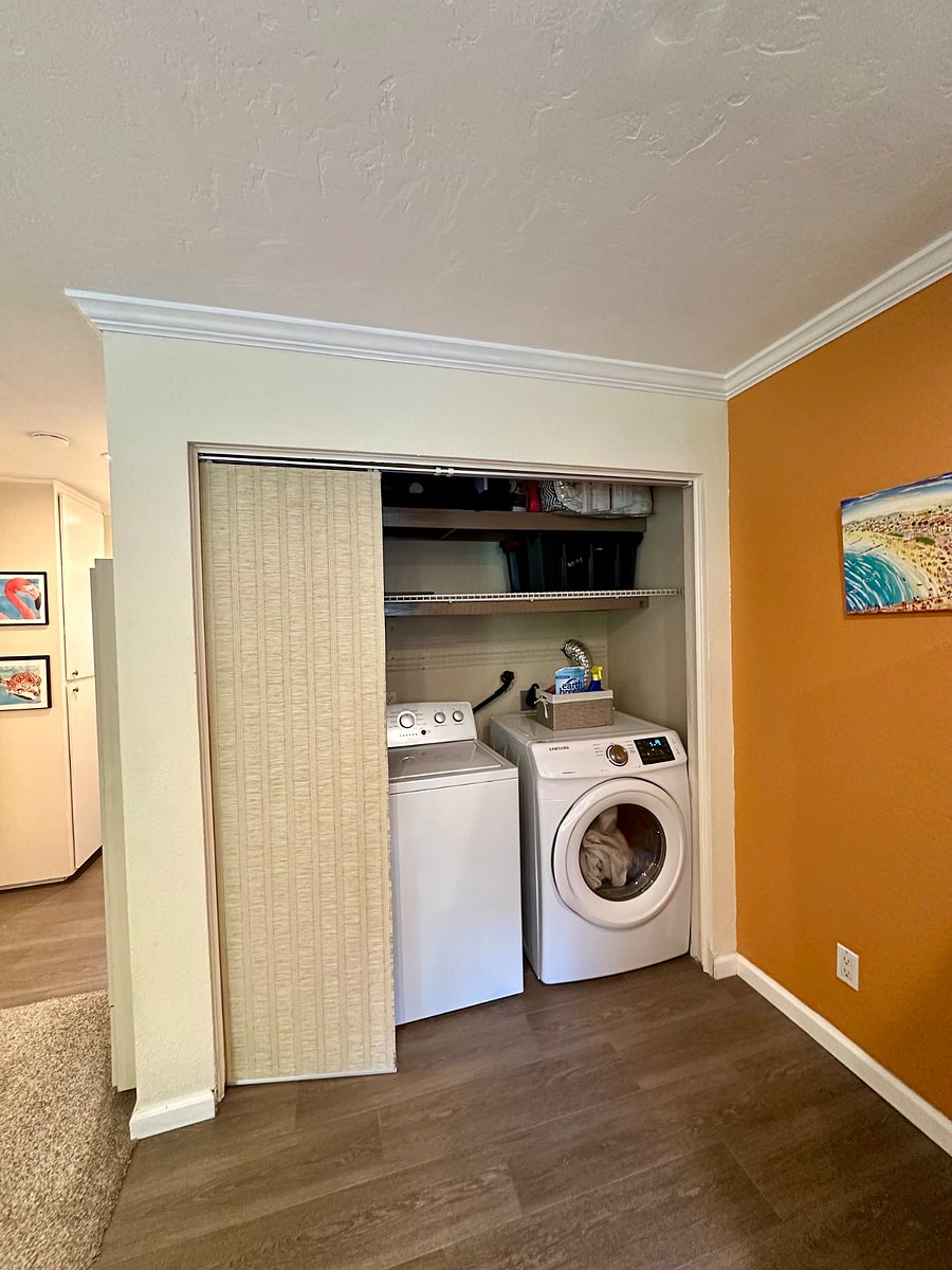 Large washer & dryer with storage above.