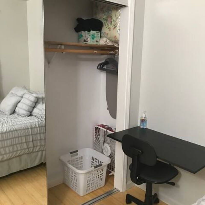 Workstation and extra amenities like fans, ironing board, iron are inside large closet
